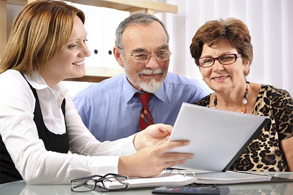 Stock photo of a woman helping a couple look over some documents